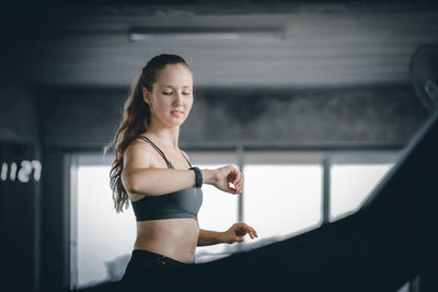 Young woman standing against wall