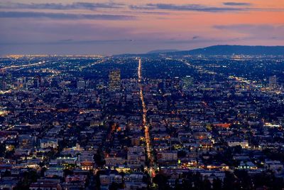 High angle view of illuminated city against sky during sunset