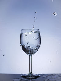 Close-up of water drops on glass against white background