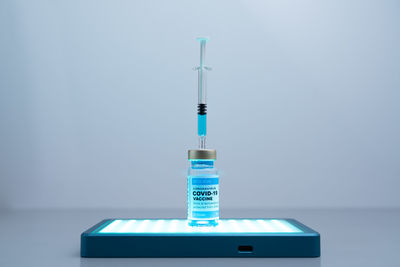 Close-up of information sign on table against wall