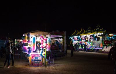 People at amusement park ride at night