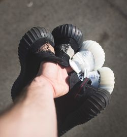 Cropped hand of man holding shoes