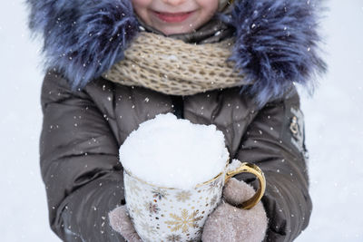 Portrait of smiling young woman standing in snow