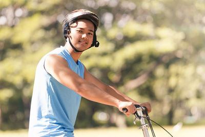 Young man riding bicycle on road