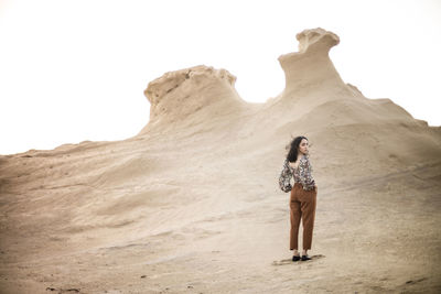 Full length of woman standing on arid landscape