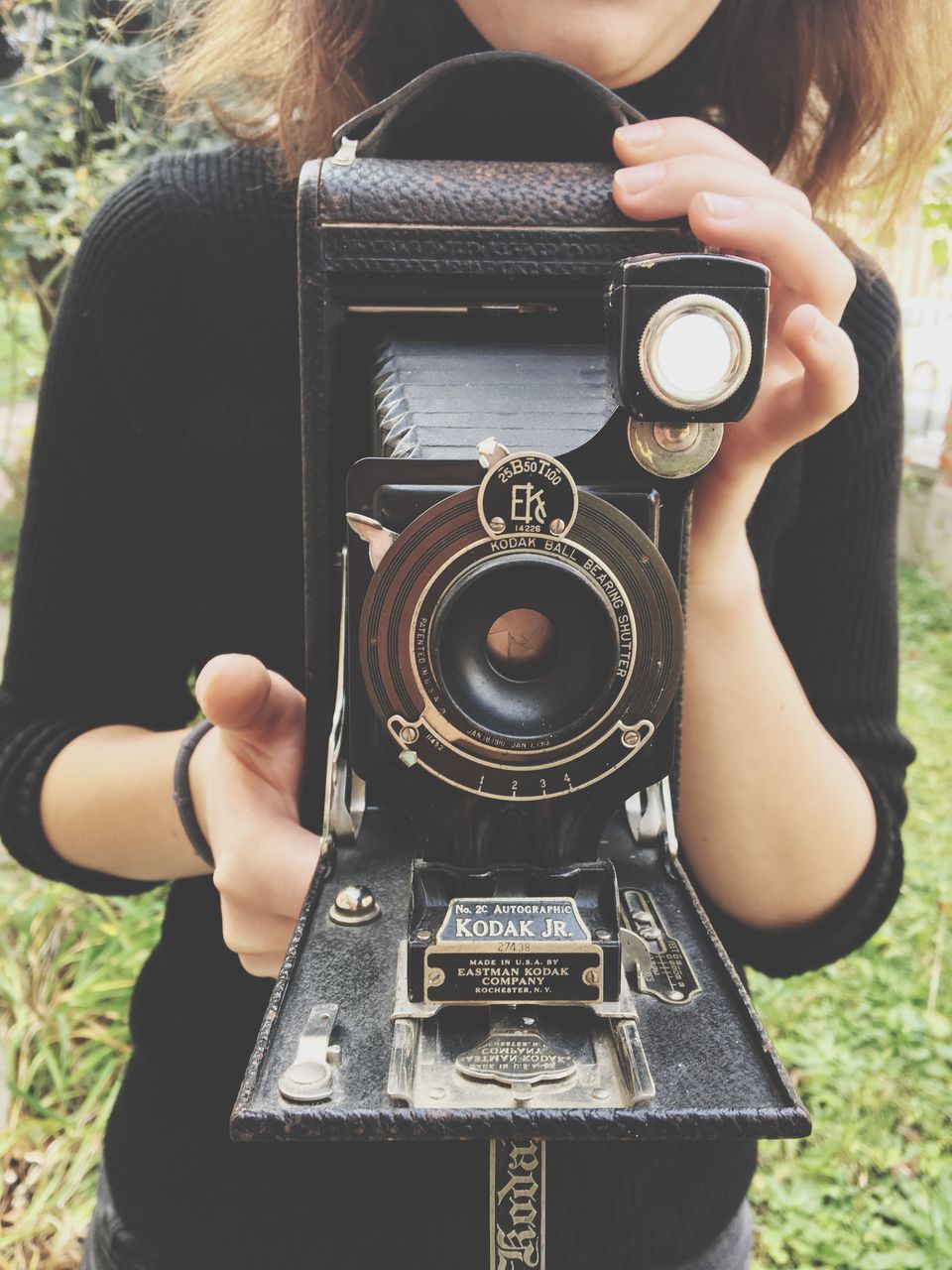 camera - photographic equipment, photography themes, one person, photographing, technology, real people, holding, photographic equipment, retro styled, leisure activity, camera, activity, lifestyles, occupation, photographer, front view, digital camera, adult, slr camera, antique