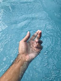 High angle view of hands in water at swimming pool