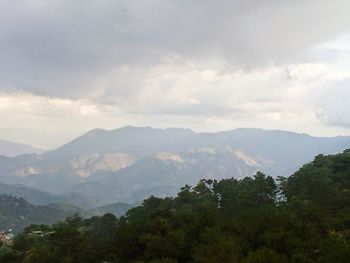 Scenic view of mountains against cloudy sky