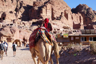 View of people and camel on rock