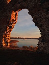 Scenic view of rock formation against sky seen through cave