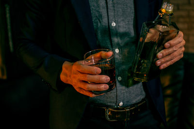 Cropped image of man holding beer bottle