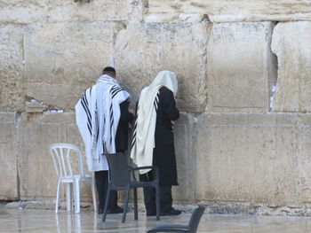 Rear view of men standing at wailing wall