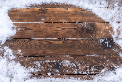 Directly above shot of snow on wooden floor during winter