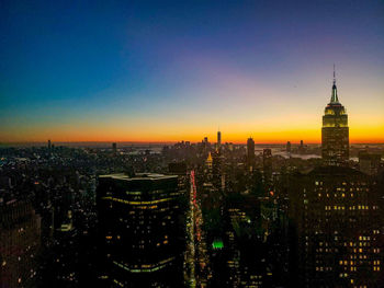 High angle view of illuminated cityscape against sky during sunset