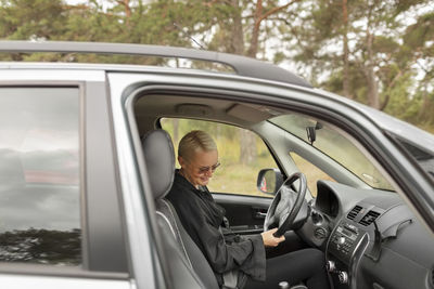 Smiling woman sitting in car