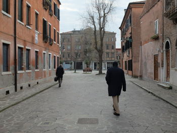 Rear view of woman walking on street in city