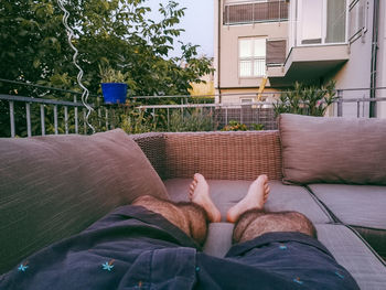 Low section of man relaxing by plants