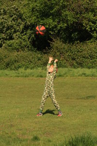 Boy playing with ball on grassy field