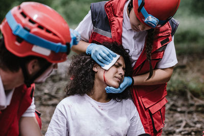 Woman cleaning blood of female accident victim