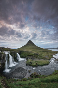 Scenic view of waterfall against sky