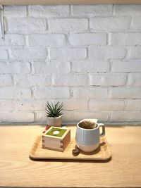 Potted plant on table against wall