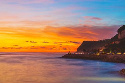 Scenic view of sea against orange sky