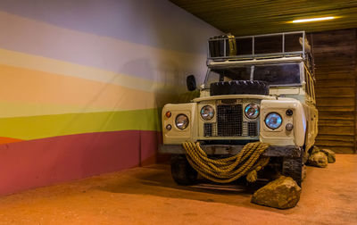 Close-up of vintage car on table against illuminated wall