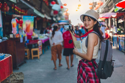 Woman standing by street market in city