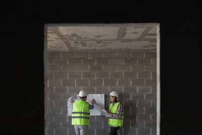 Rear view of man standing against wall