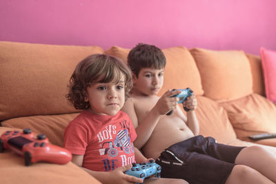 Portrait of boy sitting on sofa at home