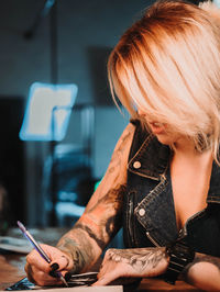 Close-up of tattooist drawing at table