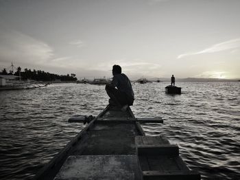 Rear view of man on sea against sky