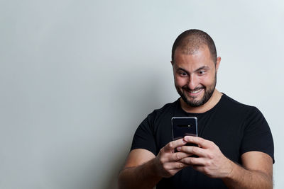 Man using smart phone against white background