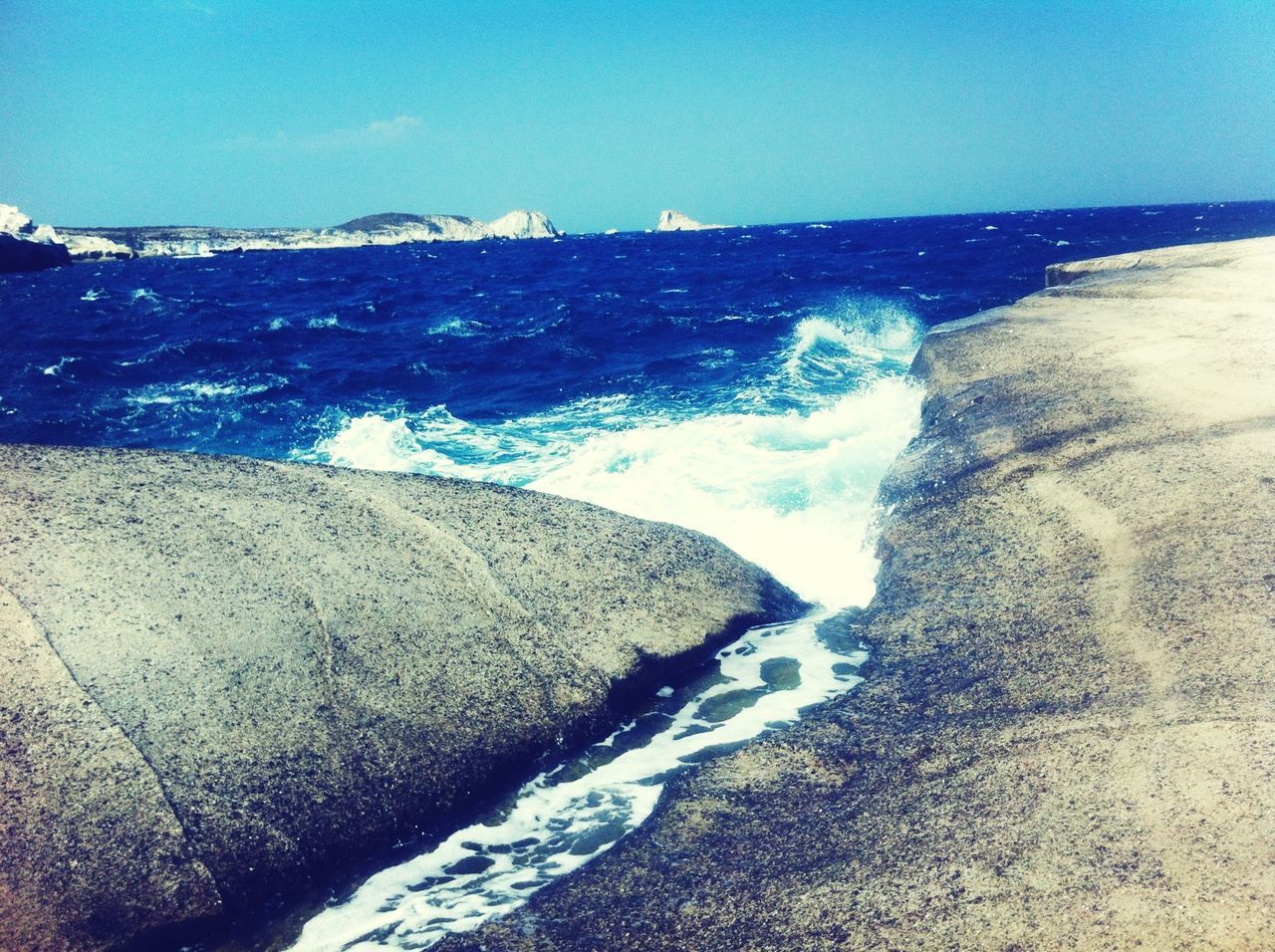 sea, water, scenics, beauty in nature, wave, horizon over water, surf, rock - object, nature, clear sky, tranquil scene, blue, tranquility, rock formation, shore, idyllic, motion, rock, splashing, sky