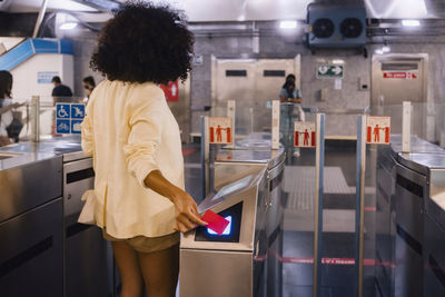 Woman scanning ticket on turnstile at subway station