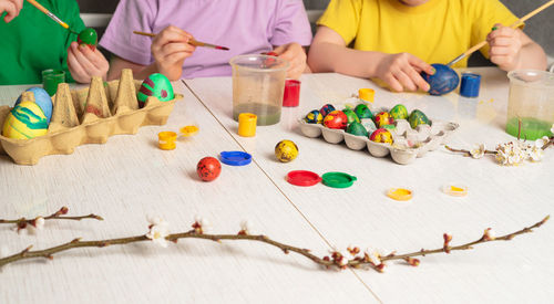 Children's hands that paint quail eggs for easter. preparing for a happy easter holiday