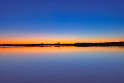 Scenic view of lake against clear sky during sunset