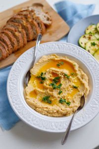 Top view of a plate of healthy homemade creamy hummus on a gray background zucchini and fresh 