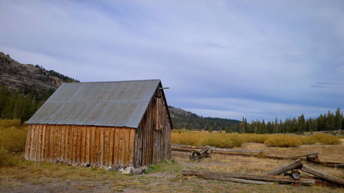 Old barn on field against sky