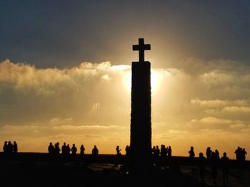 Silhouette cross against sky during sunset