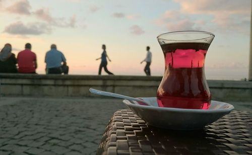 Drink on table against sky during sunset