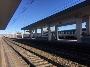 Train at railroad station against clear blue sky