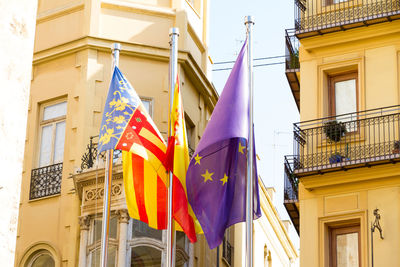 Low angle view of flags hanging on building