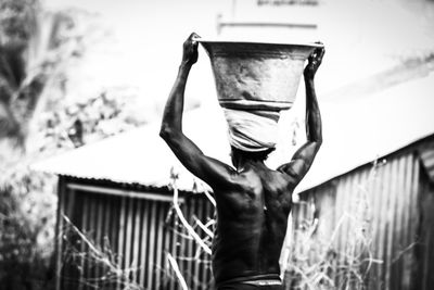 Rear view of man standing against building