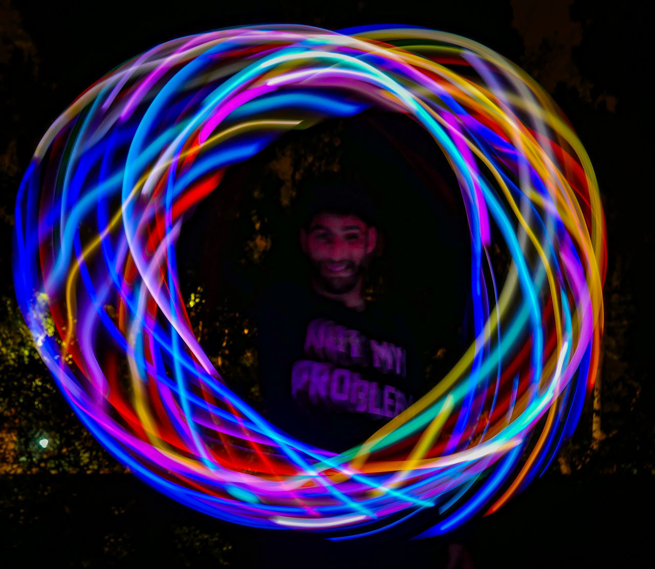 PORTRAIT OF SMILING BOY AGAINST ILLUMINATED LIGHTS