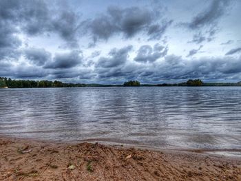 Scenic view of lake against cloudy sky