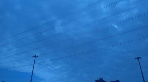 Low angle view of power lines against blue sky