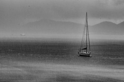 Sailboat sailing on sea against sky