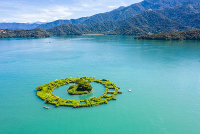 Scenic view of lake and mountains against blue sky