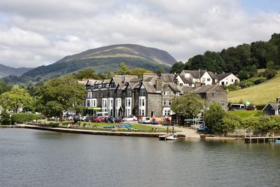 Scenic view of lake by buildings against sky